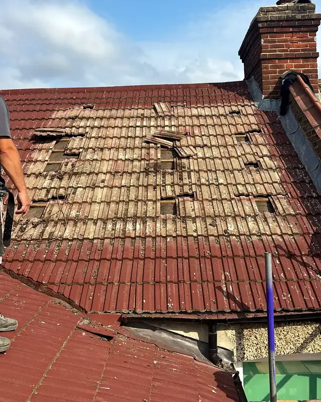 Old roof tiles on a Bromley house, painted over, with cracked and missing tiles