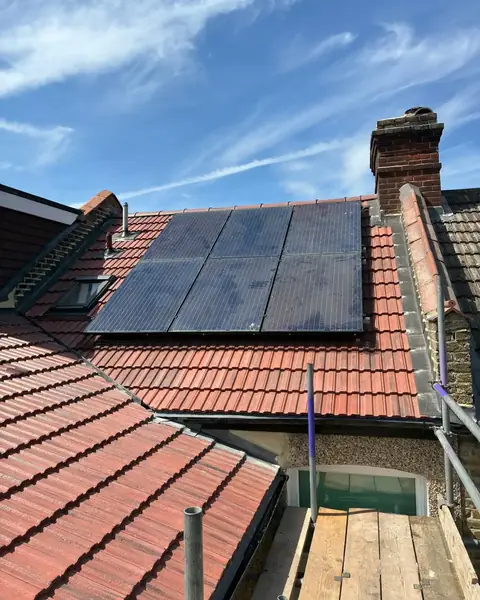 The same Bromley roof finished in new red interlocking tiles, with the solar panels refitted