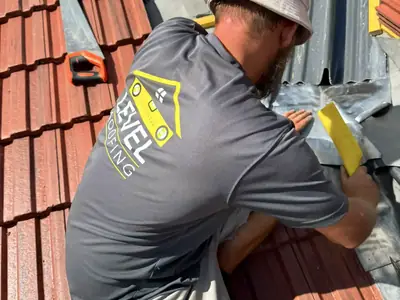 A Level Roofing roofer laying new red interlocking roof tiles
